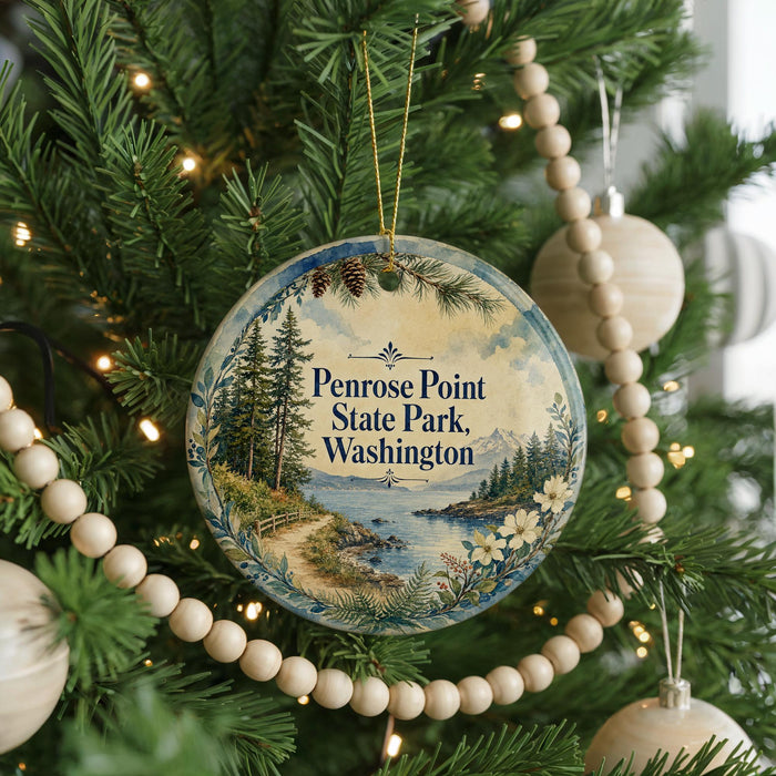 A round ornament on a Christmas tree, featuring a scenic landscape with pine trees, a lake, and mountains.