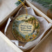 A decorative ornament in a box, featuring a scenic landscape with a waterfall and a path leading to a cliff.