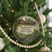 A Christmas tree decorated with ornaments, including a round ornament with a picture of Prickett's Fort State Park, West Virginia, and a beaded ornament.