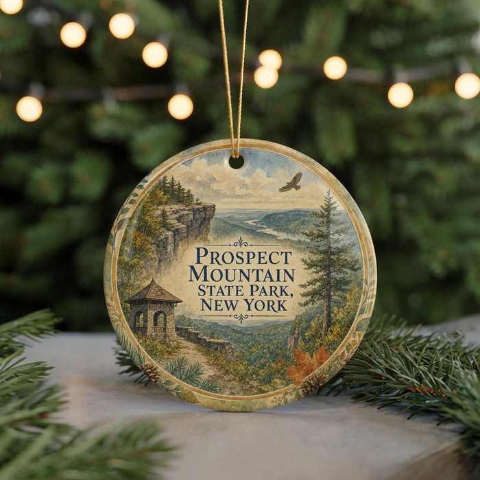 A circular ornament with a scenic mountain landscape and a bird in flight, featuring the text "Prospect Mountain State Park, New York".