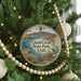 A Christmas tree ornament featuring a scenic image of Quail Creek State Park in Utah, with a bird perched on a rock in the foreground.