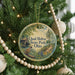 A round ornament hanging on a Christmas tree, featuring a scenic image of Quail Hollow State Park, Ohio.