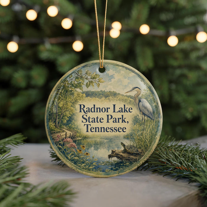 A round ornament with a scenic image of Radnor Lake State Park, Tennessee, featuring a bird, flowers, and a pond.