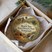 A decorative ornament in a white box, featuring an illustration of Red Clay State Historic Park in Tennessee.