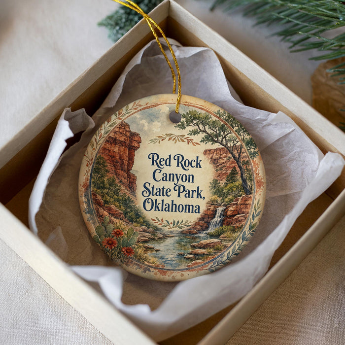 A decorative ornament in a white box, featuring a scenic landscape with a waterfall and mountains, along with the text "Red Rock Canyon State Park, Oklahoma".