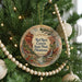 A round ornament hanging on a Christmas tree, featuring a scenic image of Red Rock Canyon State Park in Oklahoma.