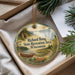 A round ornament with a scenic landscape and a canoe, hanging from a string.