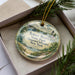 A decorative ornament in a box, featuring a scenic image of Robert Moses State Park in New York.