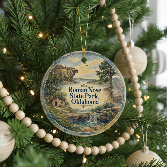 A Christmas tree decorated with ornaments, including a circular ornament with a scenic image of Roman Nose State Park, Oklahoma.