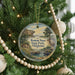 A Christmas tree decorated with ornaments, including a circular ornament with a scenic image of Roman Nose State Park, Oklahoma.