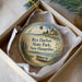 A decorative ornament in a box, featuring a lighthouse and a boat on the water, with the text " Rye Harbor State Park, New Hampshire" printed on it.