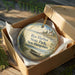 A decorative ornament in a wooden box, featuring a scenic image of Rye Harbor State Park in New Hampshire.