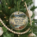 A round ornament hanging on a Christmas tree, featuring a scenic image of Salmon Lake State Park in Montana.