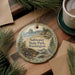 A decorative ornament with a scenic landscape of Saltwater State Park, Washington, featuring a bird, pine trees, and a body of water.