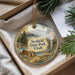 A decorative ornament in a box, featuring a scenic landscape with mountains, pine trees, and a cabin, along with the text "Scottfield State Park, Utah".