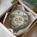 A decorative ornament in a box, featuring a lighthouse, sea birds, and a beach scene, with the text "Sea Rim State Park, Texas" printed on it.