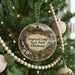 A round ornament hanging on a Christmas tree, featuring a scenic image of Sequoyah Lodge State Park, Oklahoma.