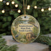 A round ornament with a painting of a serene landscape, featuring a bird, a house, and a river, hanging from a string.