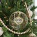 A round ornament hanging on a Christmas tree, featuring a scenic image of Silver Falls State Park, Oregon.