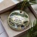 A decorative ornament featuring a scenic landscape of Singletary Lake, State Park, North Carolina, with a black bear in the foreground.