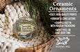 Ceramic ornaments, featuring a snowy state park ornament with a bird and waterfall, are displayed in a basket with a woven blanket.