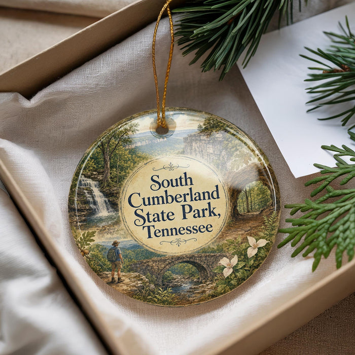 A decorative ornament with a scenic landscape of South Cumberland State Park, Tennessee, featuring a person walking along a path and a waterfall in the background.