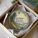 A round ornament with a scenic image of South Whidbey State Park, Washington, hanging from a string.
