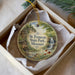 A round ornament with a scenic image of St. Francis State Park, Missouri, hanging from a string.
