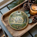 A decorative ornament featuring St. Joe State Park, Missouri, with a scenic landscape and a candle on a wooden tray.