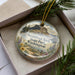 A decorative ornament in a box, featuring a scenic image of Steamboat Rock State Park in Washington.