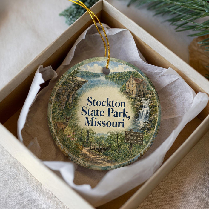 A decorative ornament in a box, featuring a scenic image of Stockton State Park, Missouri.