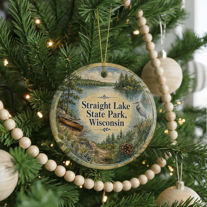 A round ornament hanging on a Christmas tree, featuring a scenic image of a lake surrounded by trees and mountains.