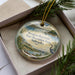 A decorative ornament in a box, featuring a scenic landscape with a lake, mountains, and a bird, along with the text "Swanson Reservoir State Recreation Area, Nebraska".