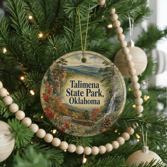 A circular ornament hanging on a Christmas tree, featuring a scenic image of Talimanena State Park in Oklahoma.