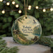 A round ornament with a scenic image of Tolmie State Park in Washington, featuring a cabin, a lake, and a bird in flight.