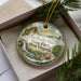A decorative ornament with a scenic landscape of Tu-Endie-Wei State Park, West Virginia, featuring a waterfall and pine trees.