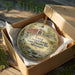 A decorative ornament in a wooden box, featuring a scenic image of the Union covered bridge in Missouri.