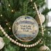 A round ornament hanging on a Christmas tree, featuring a scenic image of Utah Lake State Park and a bird in the foreground.