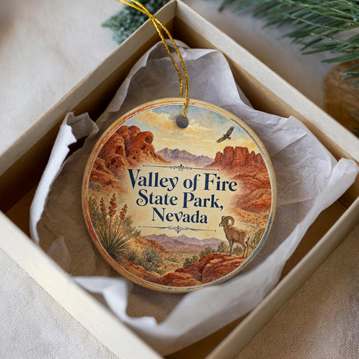 A decorative ornament in a box, featuring a desert landscape with mountains and a bird in flight.