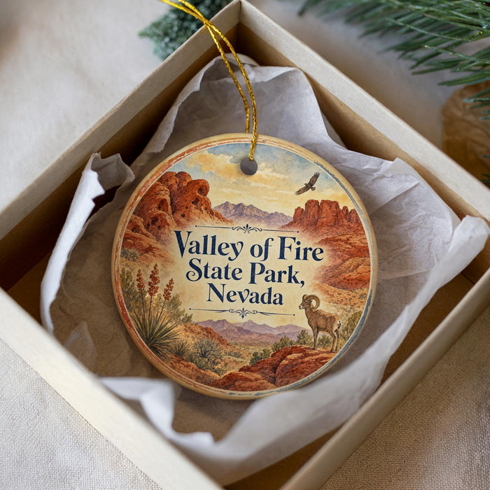 A decorative ornament in a box, featuring a desert landscape with mountains and a bird in flight.