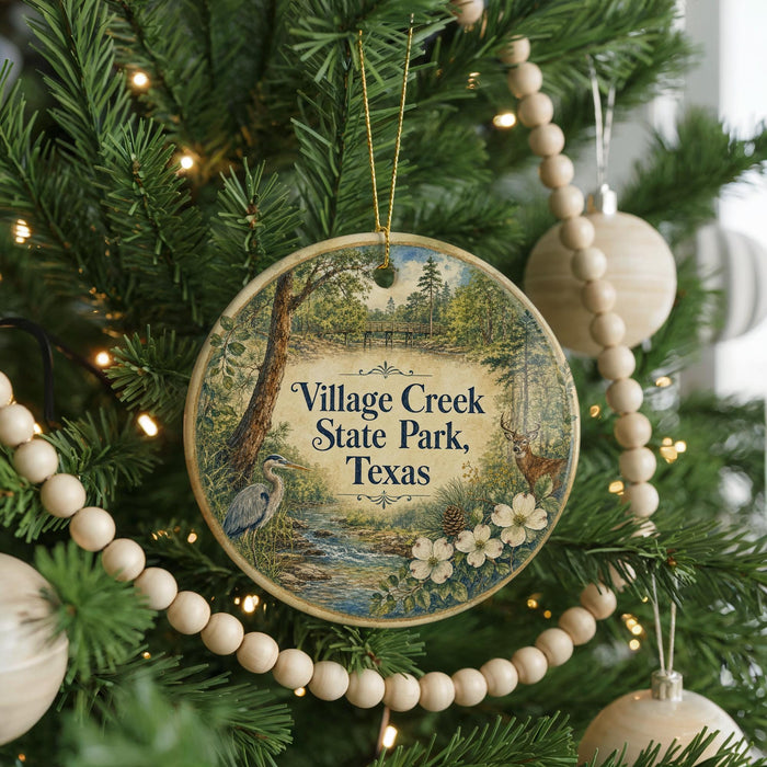 A round ornament hanging on a Christmas tree, featuring a scenic image of a park with a river and trees.