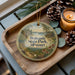A wooden tray with a decorative ornament featuring a scenic landscape of Wokonda State Park, Missouri, and pine cones.