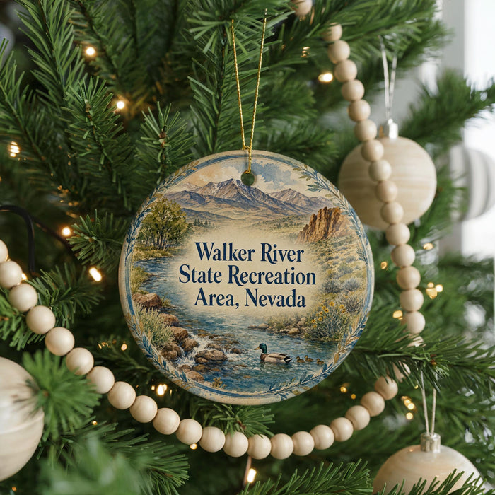 A round ornament hanging on a Christmas tree, featuring a scenic landscape with mountains, water, and wildlife.