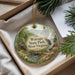 A decorative ornament with a scenic landscape of Watoga State Park, West Virginia, featuring a waterfall, pine trees, and a cabin.