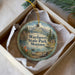 A decorative ornament in a box, featuring a scenic landscape with mountains, a lake, and a cabin, with the text "Wayfarers State Park, Montana" prominently displayed.