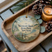 A decorative ornament featuring a scenic landscape of Westcott Beach State Park, New York, with pine cones and a lit candle on a wooden tray.