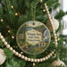 A round ornament hanging on a Christmas tree, featuring a scenic image of Whipple Dam State Park, Pennsylvania.