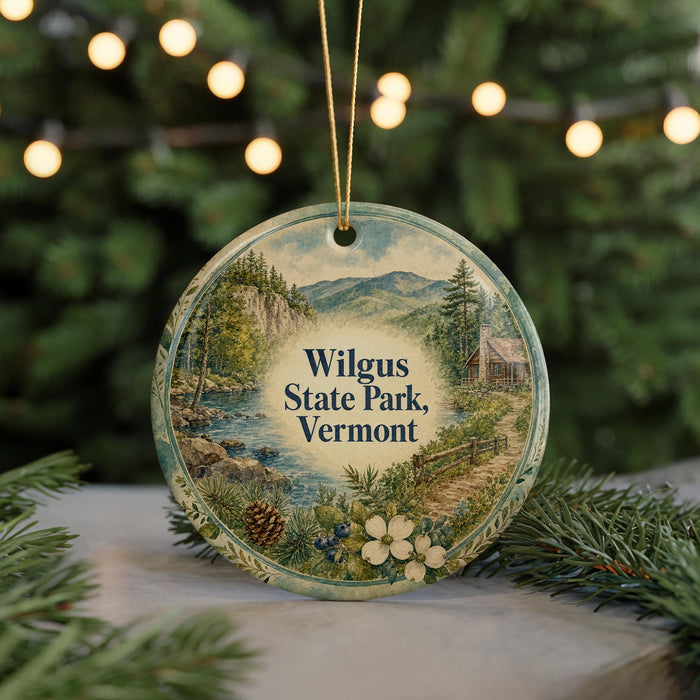 A round ornament with a scenic image of Wilgus State Park, Vermont, featuring a mountain landscape, pine trees, and a river.