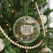 A round ornament hanging on a Christmas tree, featuring a scenic image of William B. Umstead State Park in North Carolina.