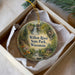A round ornament in a box, featuring a scenic image of the Willow River State Park in Wisconsin.